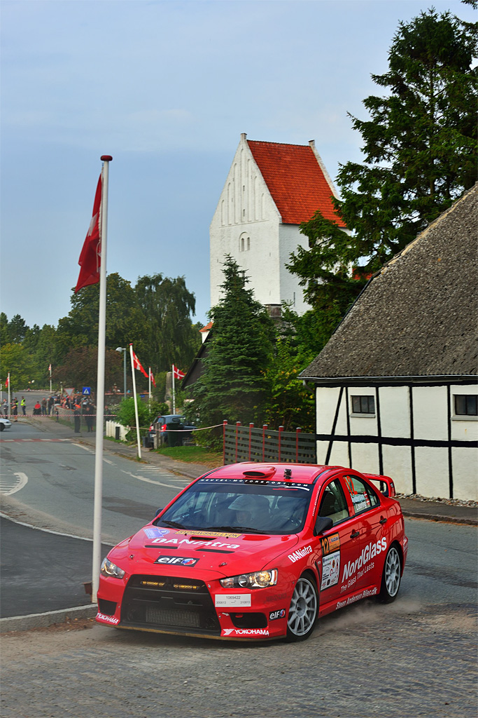 Horslunde på Vestlolland var klædt i festdragt, da danmarksmesterskabet i rally lagde vejen forbi. Her runder Steen Andersens og Iben Lourings nye Mitsubishi Lancer Evo X et skarpt hjørne midt i byen
(Foto: Michael Eisenberg)